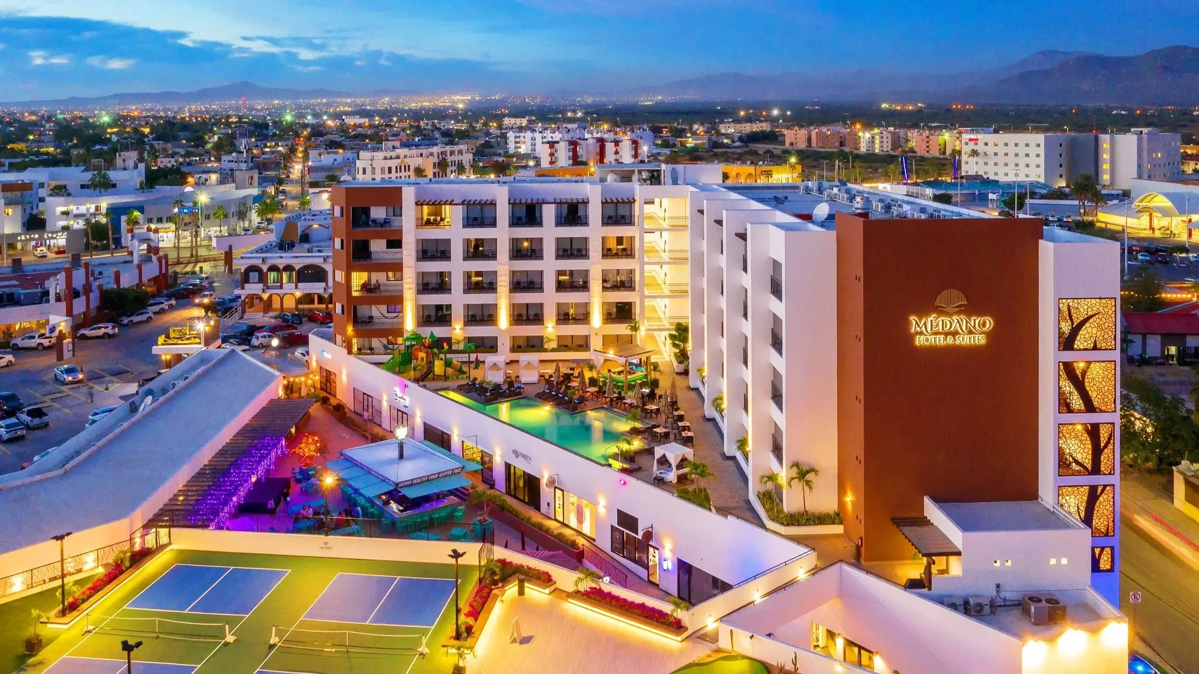 Médano Hotel & Spa at night, with the pool and downtown Cabo San Lucas
